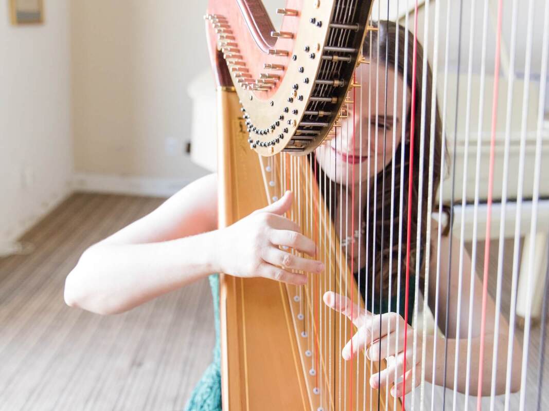 Kristie Smith playing harp at her teaching studio in Las Vegas, photo by Sabrina W Photography.